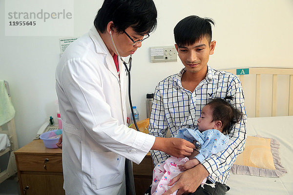 Tam Duc Heart Hospital. Ein Arzt hört das Herz eines jungen Mädchens ab. Ho-Chi-Minh-Stadt. Vietnam.