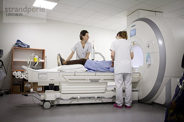 Reportage in einem medizinischen Bildgebungsdienst in einem Krankenhaus in Savoie  Frankreich. Zwei Techniker bereiten einen Patienten für eine MRT-Untersuchung vor.