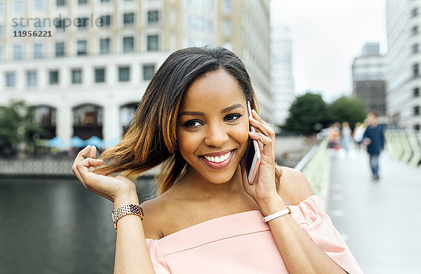 Lächelnde Frau am Telefon in der Stadt
