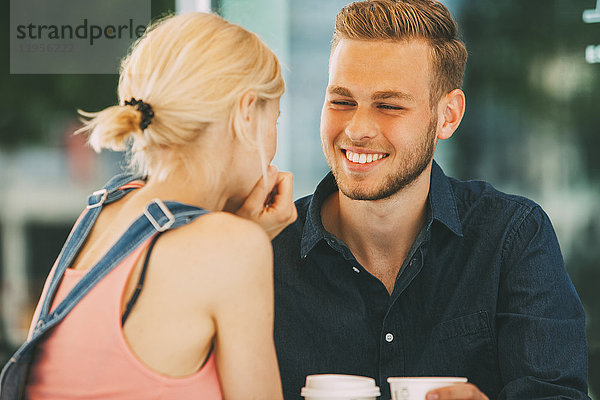Porträt eines glücklichen jungen Mannes  der mit seiner Freundin Kaffee trinkt.