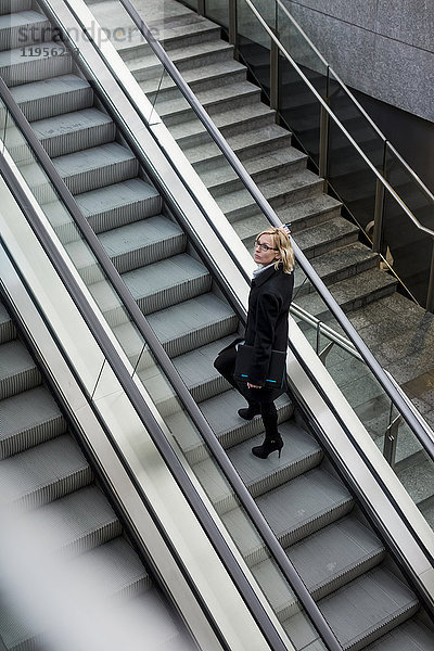 Geschäftsfrau auf der Rolltreppe