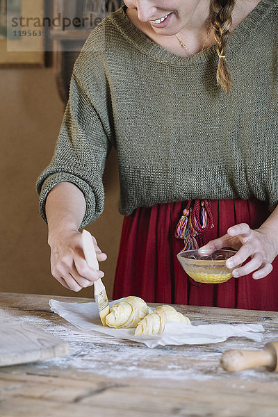 Nahaufnahme der Frau bei der Zubereitung von hausgemachten Croissants