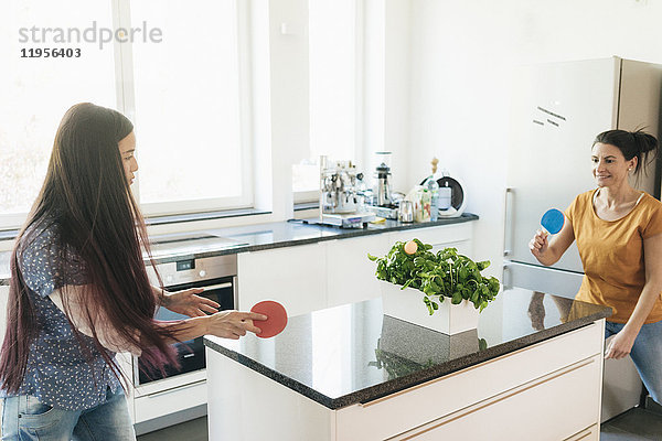 Zwei Frauen spielen Tischtennis auf der Küchentheke