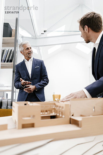 Zwei Geschäftsleute mit Architekturmodell im Büro