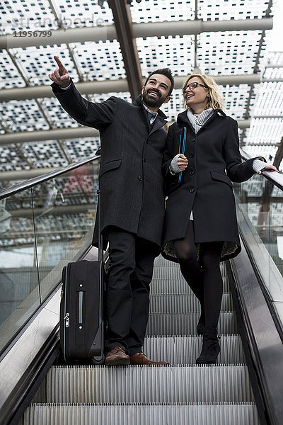 Geschäftsmann und Geschäftsfrau auf der Rolltreppe