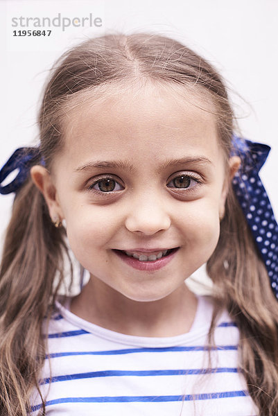 Porträt eines lächelnden kleinen Mädchens mit Zöpfen