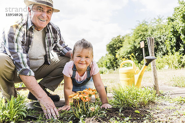 Porträt des glücklichen Großvaters und der Enkelin im Garten