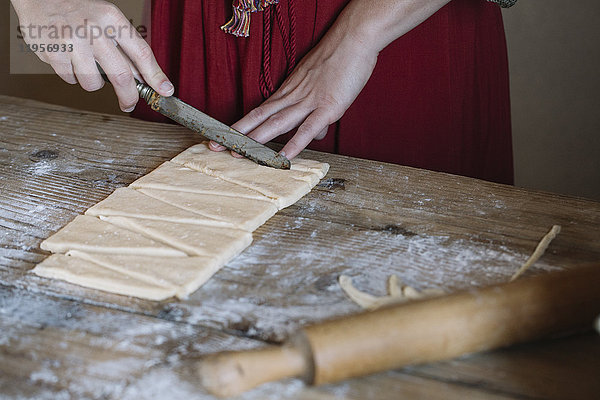 Nahaufnahme einer Frau bei der Zubereitung von Croissants