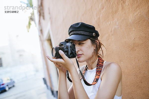 Junge Frau mit Hut fotografiert mit Kamera