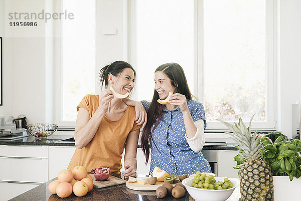 Zwei glückliche Frauen in der Küche bei der Zubereitung von Obst