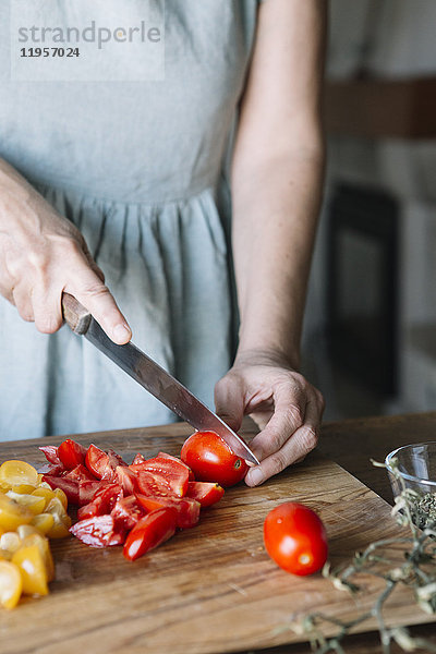 Nahaufnahme einer Frau beim Schneiden von frischen Tomaten
