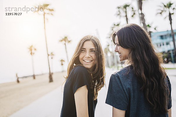 Zwei glückliche junge Frauen an der Strandpromenade