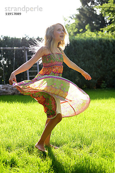 Glückliches Mädchen in einem Kleid im Garten