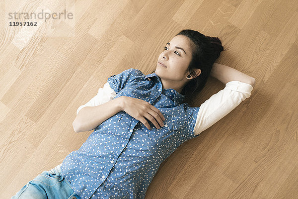 Frau auf Holzboden liegend