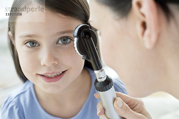 Eine Ärztin untersucht das Auge eines Mädchens.