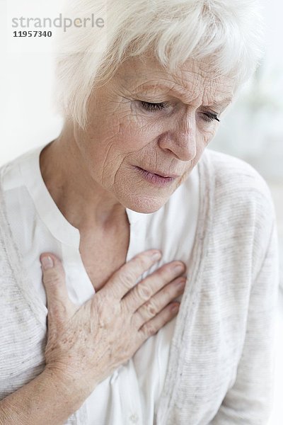 MODELL FREIGEGEBEN. Ältere Frau berührt Brust.