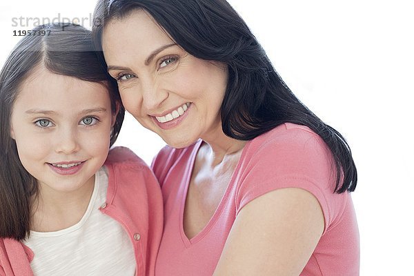 Mutter und Tochter lächeln in Richtung Kamera  Porträt.