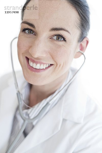 MODELL FREIGEGEBEN. Weiblicher Arzt mit Stethoskop  lächelnd.