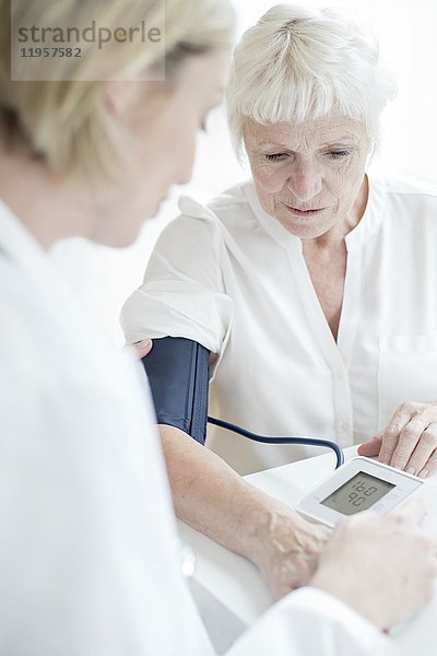 MODELL FREIGEGEBEN. Ältere Frau lässt sich den Blutdruck messen.