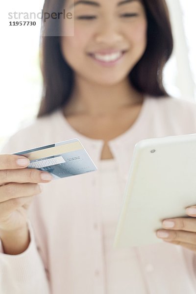 Junge Frau mit Kreditkarte und Smartphone in der Hand  Nahaufnahme.
