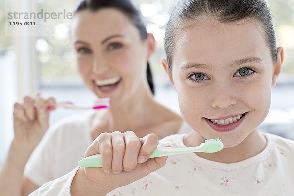Mutter und Tochter beim Zähneputzen.