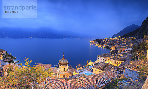Panorama des Gardasees und der typischen Stadt Limone Sul Garda in der Abenddämmerung  Provinz Brescia  Italienische Seen  Lombardei  Italien  Europa