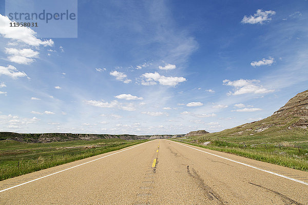 Blauer Himmel über einem Highway durch die Badlands von Alberta  nahe Drumheller  Alberta  Kanada  Nordamerika