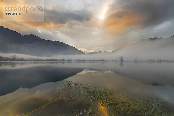 Berge spiegeln sich in der Morgendämmerung im Wasser  Pozzo di Riva Novate  Mezzola  Chiavenna-Tal  Lombardei  Italien  Europa