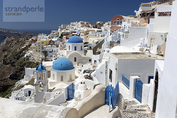 Klassischer Blick auf das Dorf Oia mit seinen blauen Kuppelkirchen und bunten Häusern  Oia  Santorin  Kykladen  Griechische Inseln  Griechenland  Europa