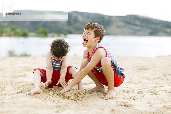 Brüder (4-5  6-7) spielen am Strand am See
