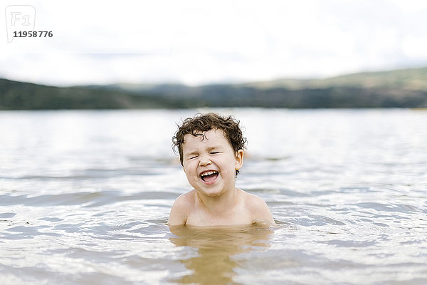 Lächelnder Junge ( 4-5) beim Schwimmen im See