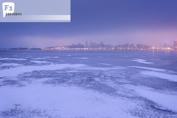 Ukraine  Gebiet Dnepropetrowsk  Stadt Dnepropetrowsk  Dramatischer Himmel über zugefrorenem Fluss in der Abenddämmerung