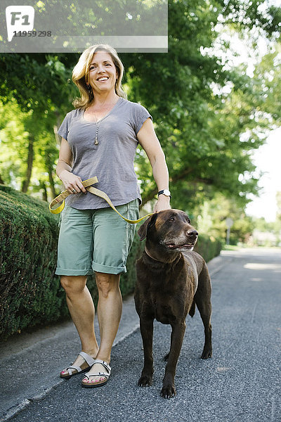 Frau geht mit Labrador Retriever spazieren