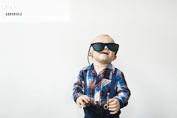 Studioaufnahme eines kleinen Jungen (12-17 Monate) mit Sonnenbrille