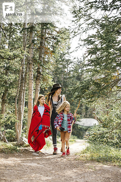 Mutter mit Sohn (6-7) und Tochter (8-9) beim Wandern im Wald