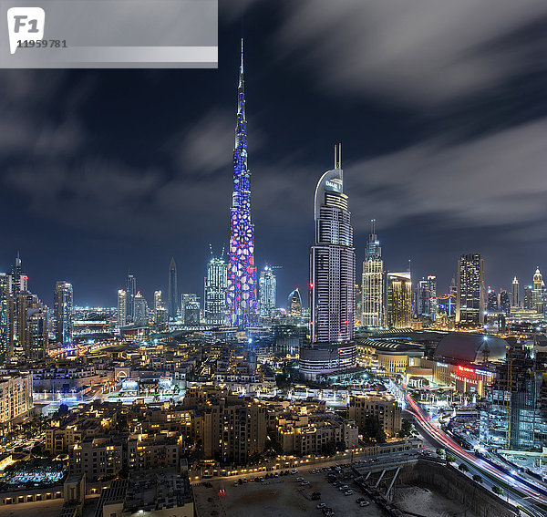 Stadtbild von Dubai  Vereinigte Arabische Emirate in der Abenddämmerung  mit dem Wolkenkratzer Burj Khalifa und beleuchteten Gebäuden im Zentrum.