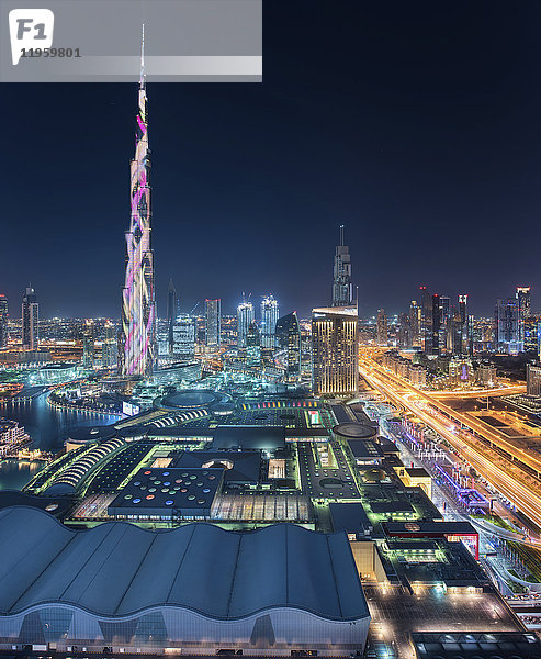 Stadtlandschaft von Dubai  Vereinigte Arabische Emirate in der Abenddämmerung  mit dem beleuchteten Wolkenkratzer Burj Khalifa im Vordergrund.