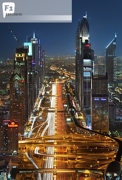 Stadtlandschaft mit Wolkenkratzern und beleuchteter Straße in Dubai  Vereinigte Arabische Emirate in der Abenddämmerung.