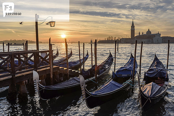 Gondeln vertäut auf einem Kanal in Venedig  Italien  bei Sonnenaufgang.