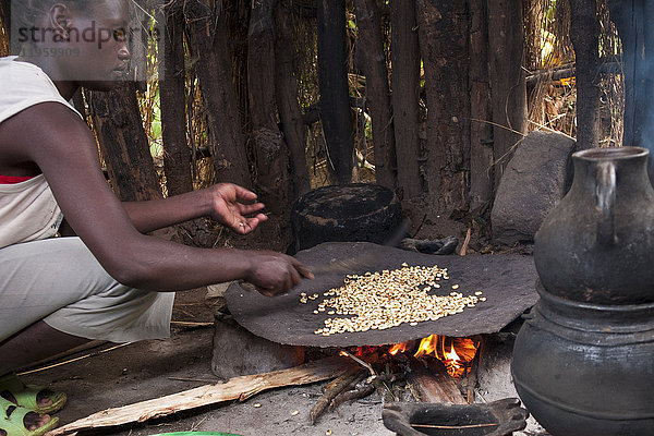 Eine Frau röstet Kaffeebohnen auf einem offenen Feuer  Äthiopien  Afrika