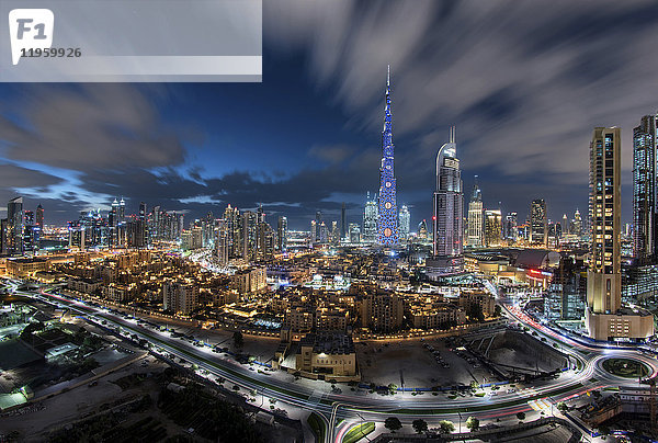Stadtbild von Dubai  Vereinigte Arabische Emirate in der Abenddämmerung  mit dem beleuchteten Wolkenkratzer Burj Khalifa in der Mitte.