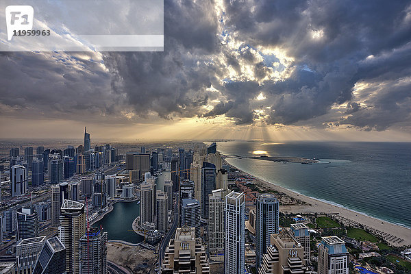 Stadtbild von Dubai  Vereinigte Arabische Emirate unter bewölktem Himmel  mit Wolkenkratzern und der Küstenlinie des Persischen Golfs.