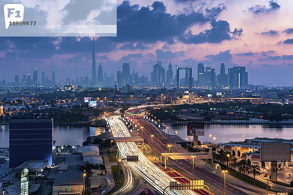 Stadtbild von Dubai  Vereinigte Arabische Emirate in der Abenddämmerung  mit der Autobahn über den Jachthafen und Wolkenkratzern in der Ferne.