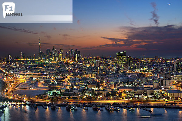 Stadtbild von Dubai  Vereinigte Arabische Emirate in der Abenddämmerung  mit beleuchteten Wolkenkratzern in der Ferne.