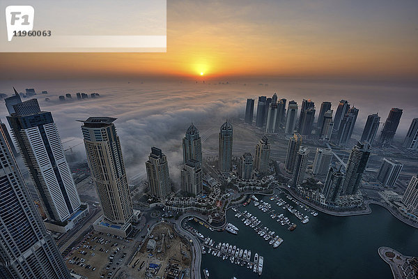 Luftaufnahme des Stadtbildes von Dubai  Vereinigte Arabische Emirate in der Abenddämmerung  mit Wolkenkratzern und dem Yachthafen im Vordergrund.