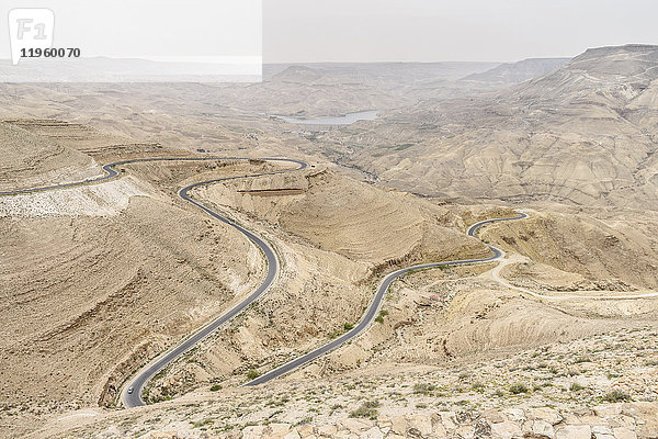 Luftaufnahme einer Landstraße  die sich durch die jordanische Wüstenwüste schlängelt  Jordanien.