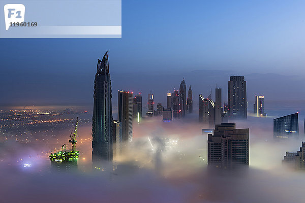 Blick auf beleuchtete Wolkenkratzer über den Wolken in Dubai  Vereinigte Arabische Emirate.