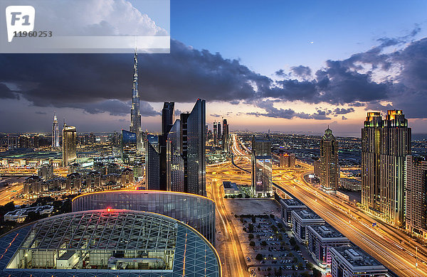 Stadtlandschaft mit beleuchteten Wolkenkratzern  Dubai  Vereinigte Arabische Emirate in der Abenddämmerung.