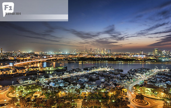 Stadtlandschaft mit beleuchteten Wolkenkratzern und Yachthafen in Dubai  Vereinigte Arabische Emirate in der Abenddämmerung.