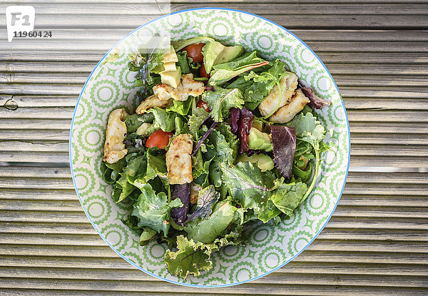 Hochwinkelaufnahme einer Schüssel Salat mit grünen Blättern  Avocado und Huhn.